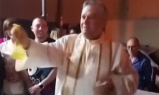 Il prete impone la benedizione… con lo spruzzino