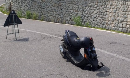 L'asfalto cede sotto la ruota e il motorino finisce... in buca