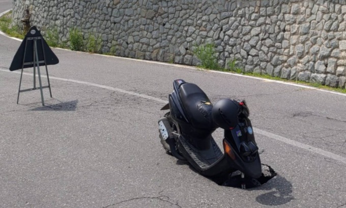 L’asfalto cede sotto la ruota e il motorino finisce… in buca