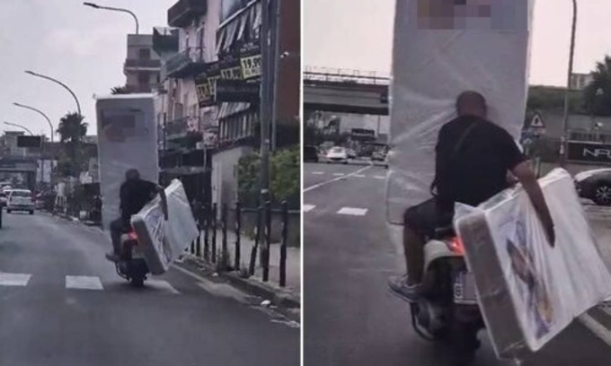 In motorino con due enormi materassi (e uno gli copre del tutto la visuale)